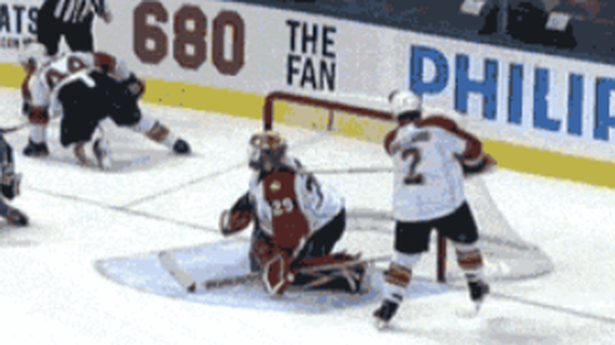 Hockeyspelaren slår sin egen målvakt med klubban. 